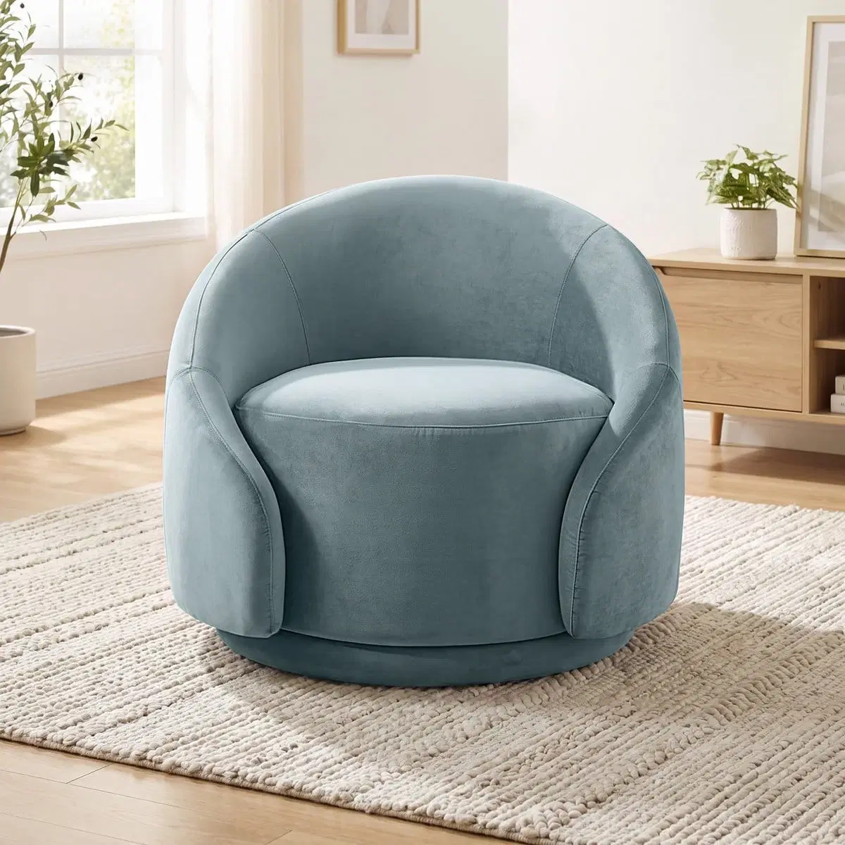 Front view of a light blue barrel swivel chair on a textured cream rug in a bright living room