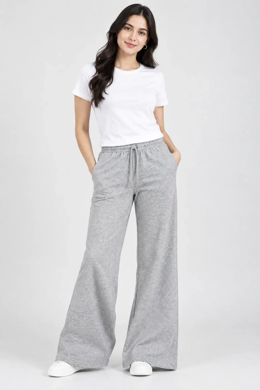Front full-length view of grey wide-leg lounge pants with drawstring waist and side pockets, styled with a white tee
