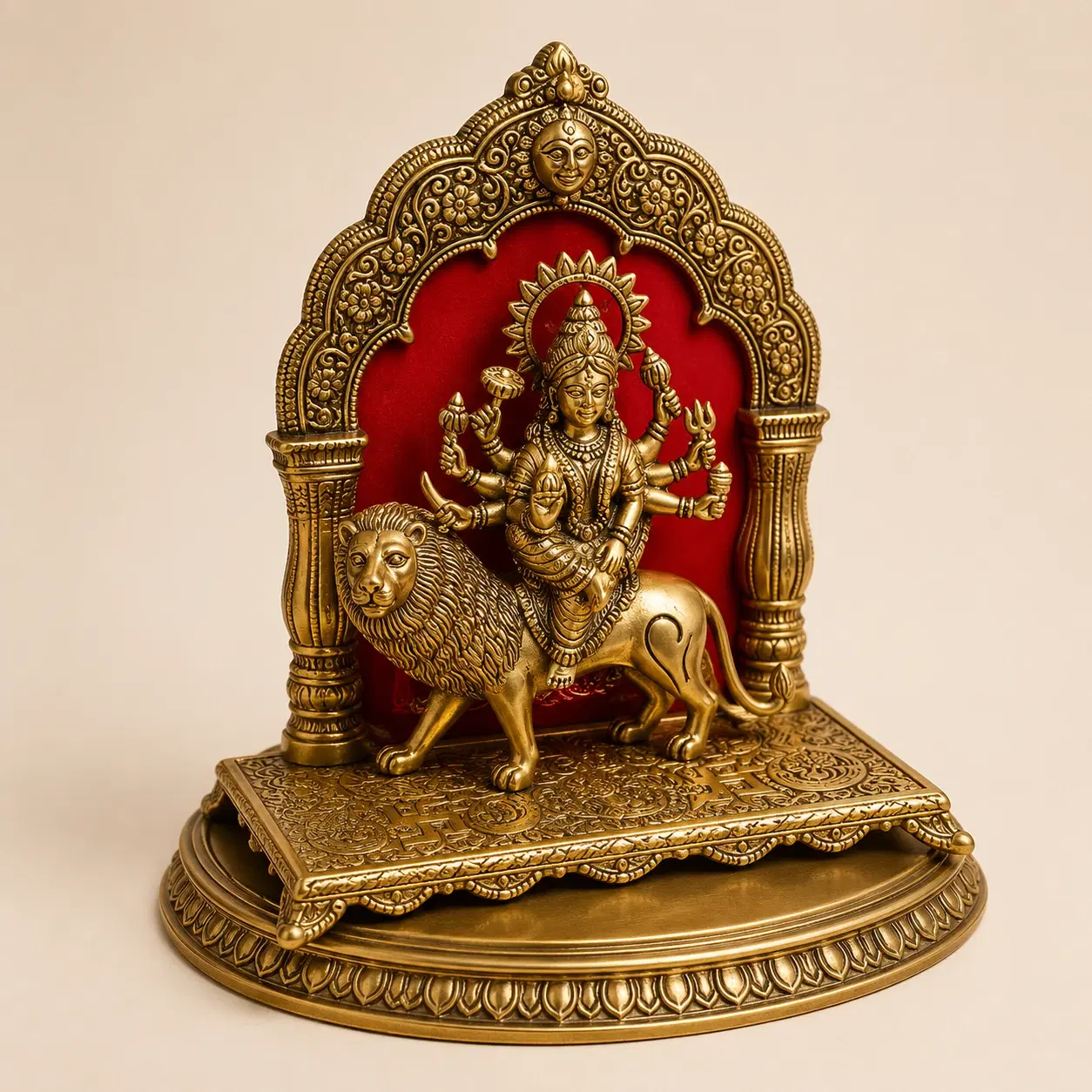 Front view of brass-tone Durga murti with lion, carved arch pillars and round embossed base