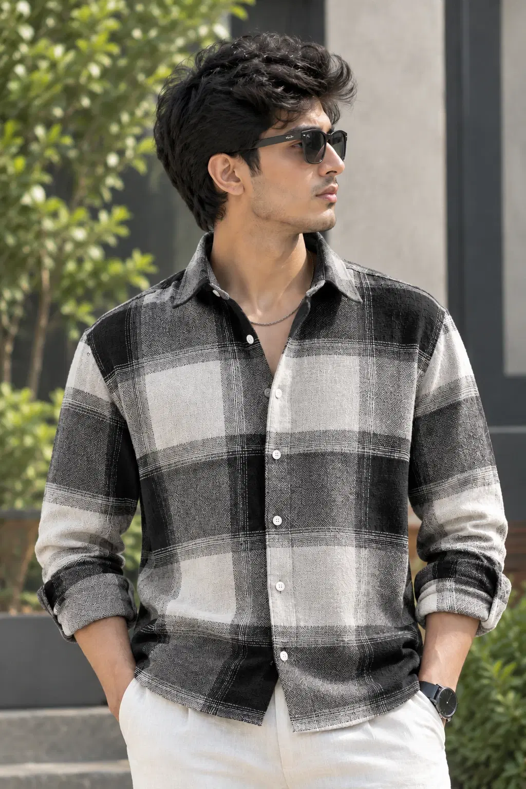 Front view of black and white checked men's shirt worn with sleeves rolled up