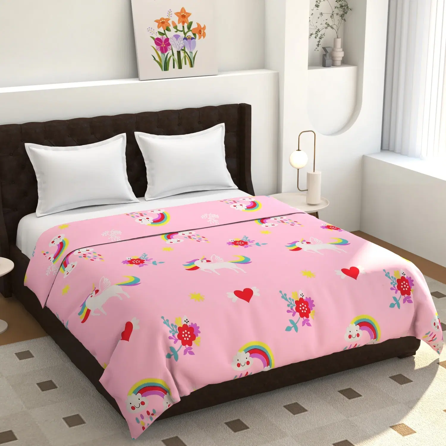 Pink bedsheet spread on a bed with unicorn, rainbow, heart and floral print