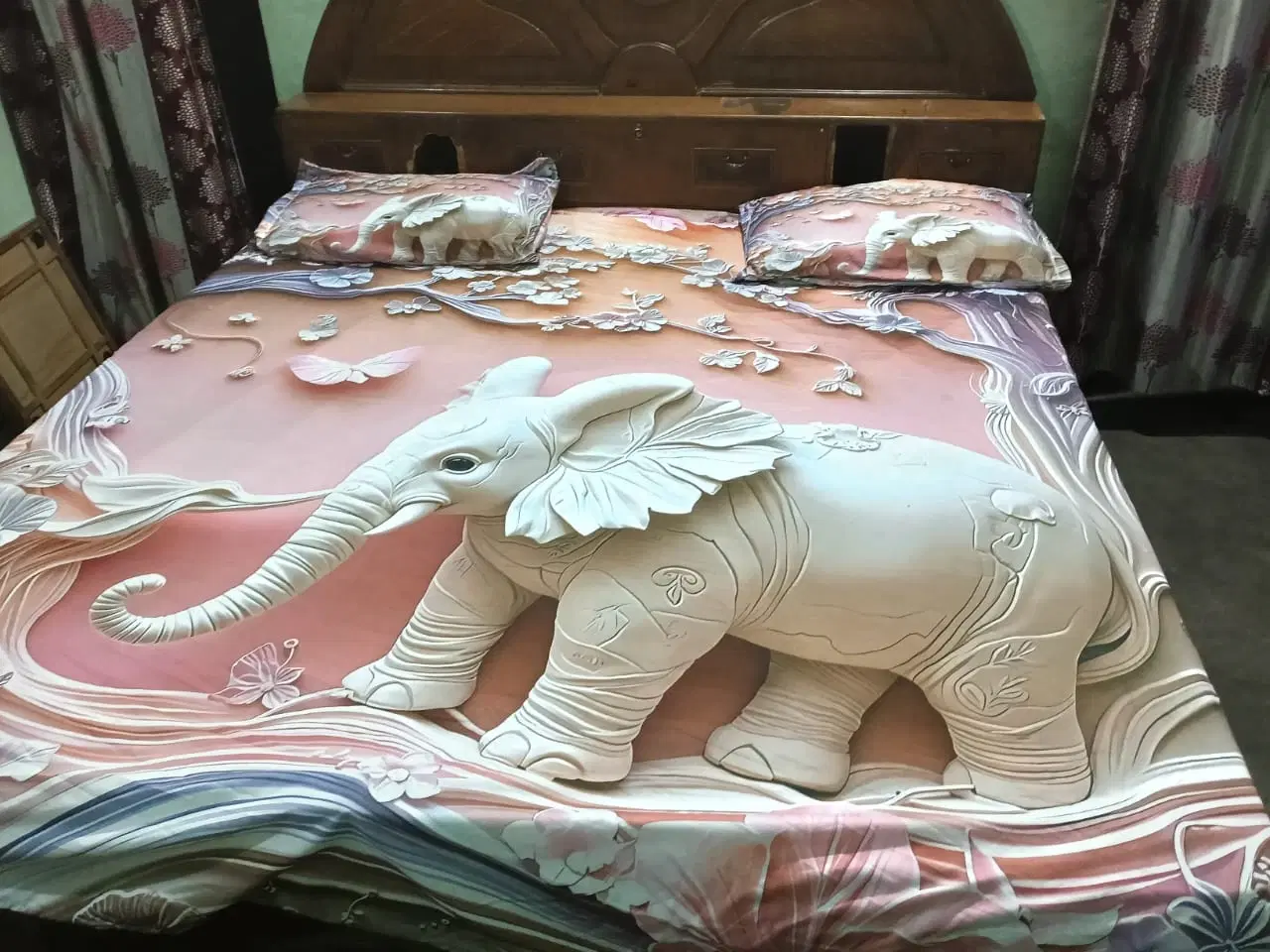 Double bed sheet spread on a bed with large white elephant print and two matching elephant pillow covers