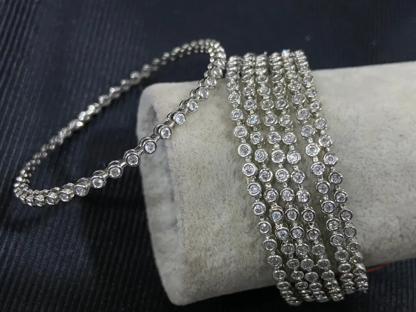 Silver-tone crystal wrap bracelet draped over a velvet display, showing bezel-set round stones