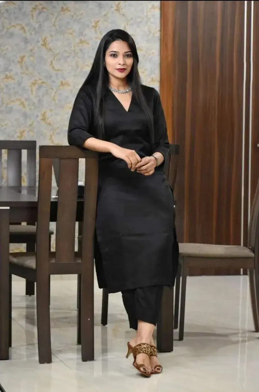 Full-length view of a woman wearing a solid black straight kurta with 3/4 sleeves and side slits