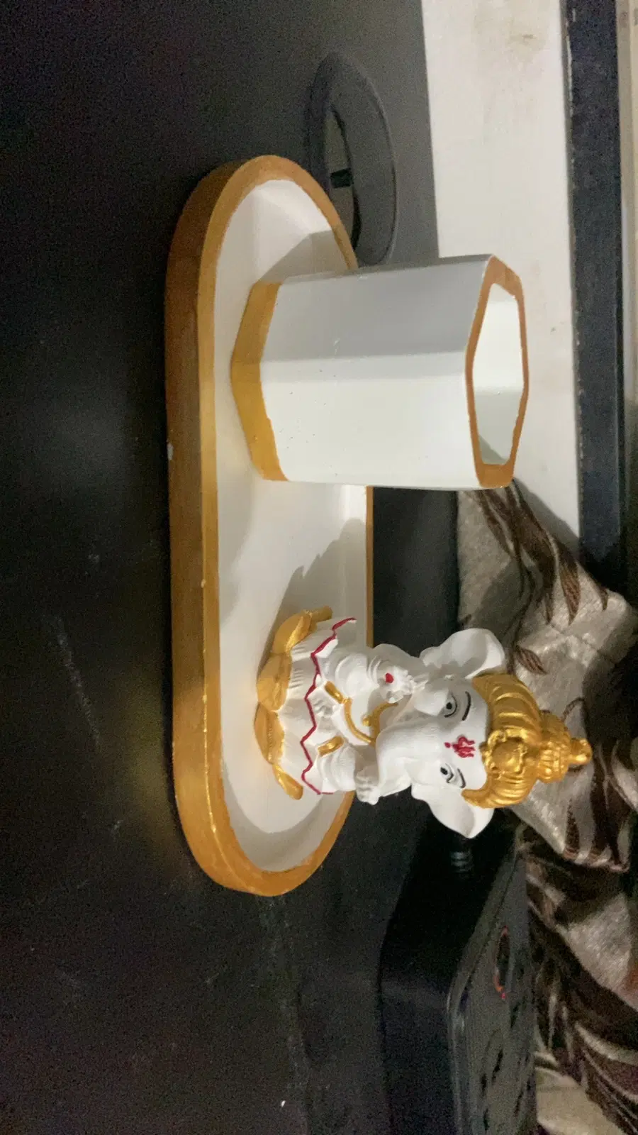 White and gold oval desk organizer with hexagonal pen holder and small Ganesha figurine on the base