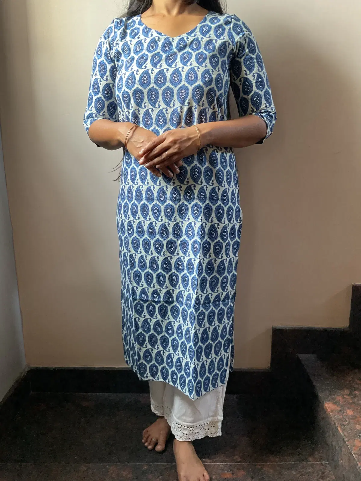 Woman wearing a blue and white paisley printed straight kurta with three-quarter sleeves