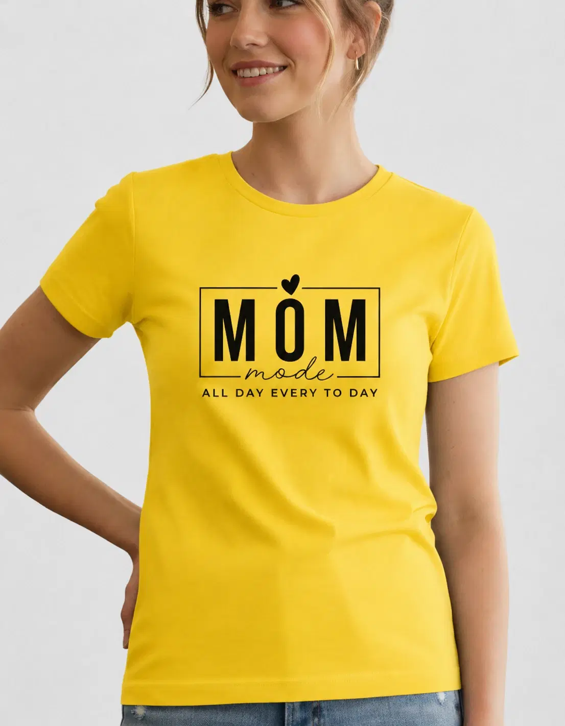 Woman wearing a bright yellow crew-neck T-shirt with black "Mom Mode" text print