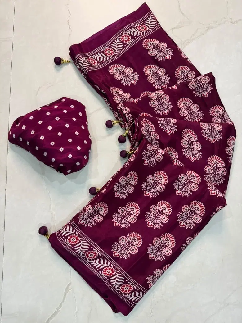 Purple printed saree with white floral motifs, border design, tassels, and matching blouse piece